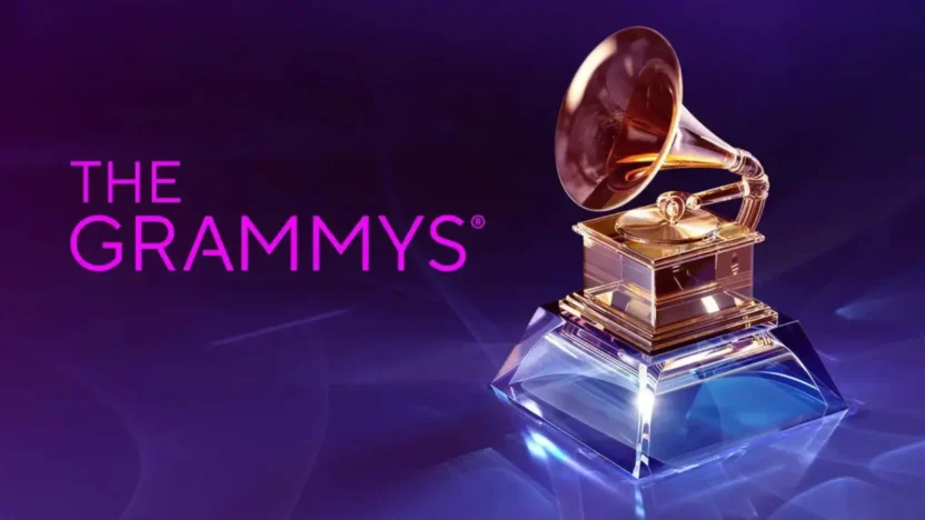 Zlatá gramofonová soška na průhledném podstavci, symbol cen Grammy, na fialovo-modrém pozadí s textem 'The Grammys'