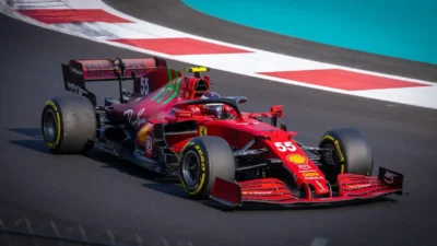 Závodní monopost Ferrari F1 číslo 55 na okruhu během Velké ceny, sponzoři Shell, Ray-Ban a Pirelli viditelní na karoserii