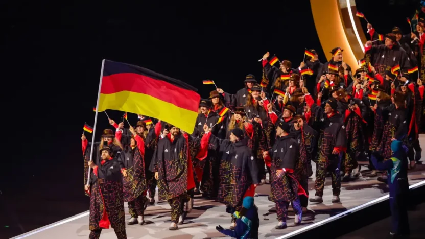 Team Deutschland bei der Eröffnungsfeier der Olympischen Winterspiele 2026 in Mailand – mit Fahne und traditioneller Einmarschkleidung auf der Bühne.
